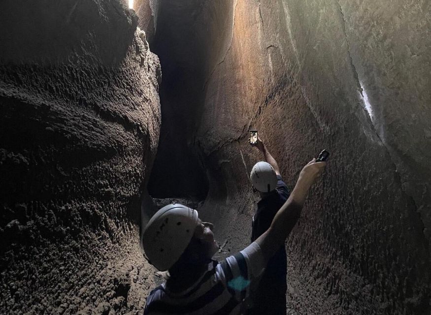 Catania: Guided Tour of Etna with Farm Visit & Food Tasting - Entering a lava-flow cave with helmet and torch