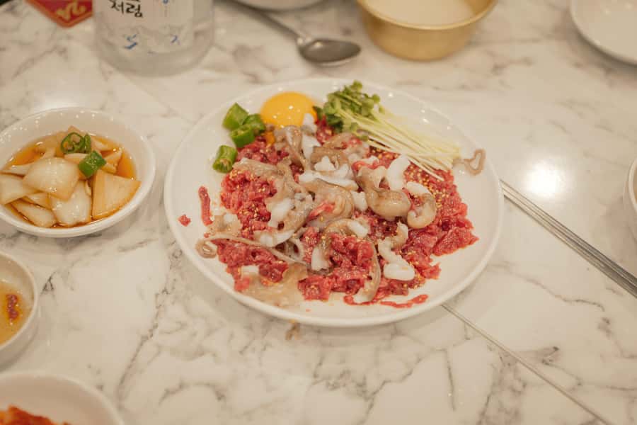 Seoul: Palace, Temple and Market Guided Foodie Tour at Night - Trying live octopus, beef tartare, and kkwabaegi